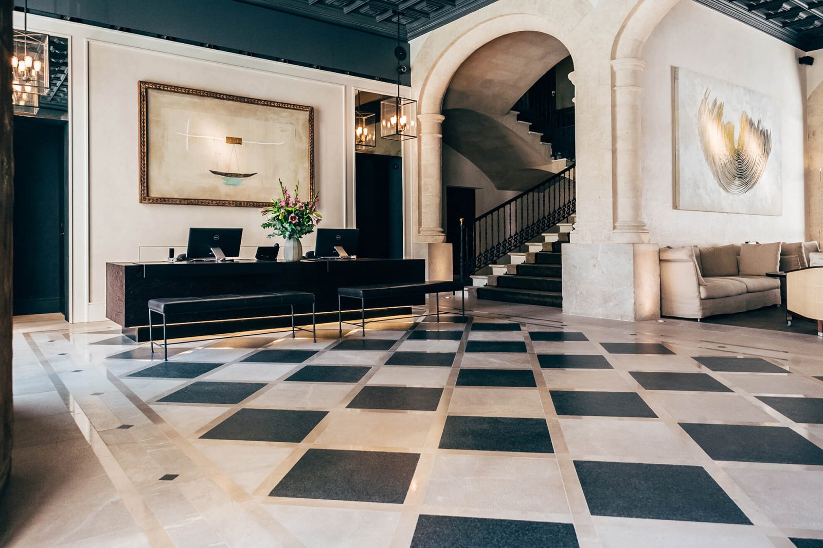 Detail of the hall with the front desk and majestic stairs at Sant Francesc Hotel Boutique