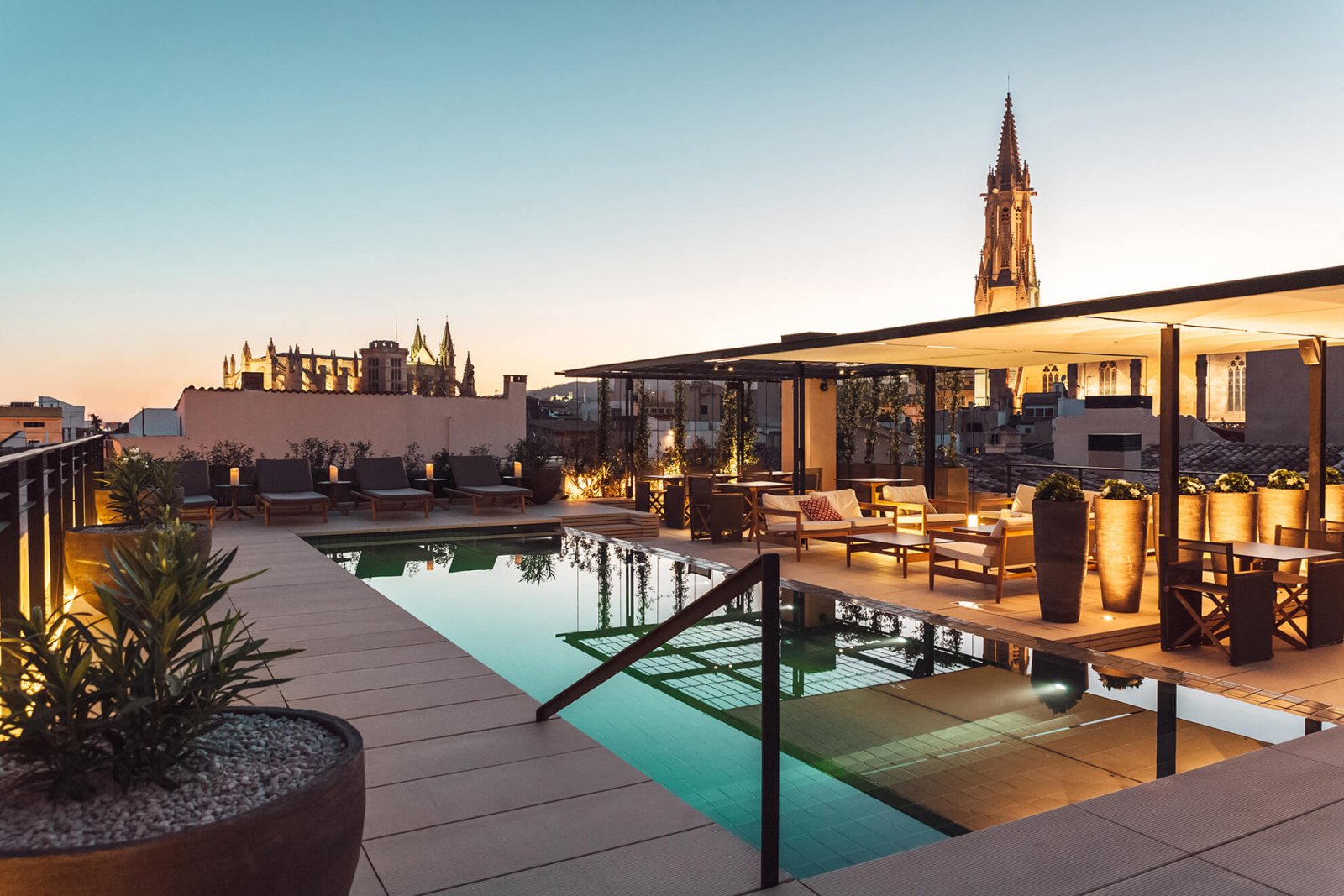 View of the upper terrace with chill out area, pool and views of the city at Sant Francesc Hotel Boutique during sunset