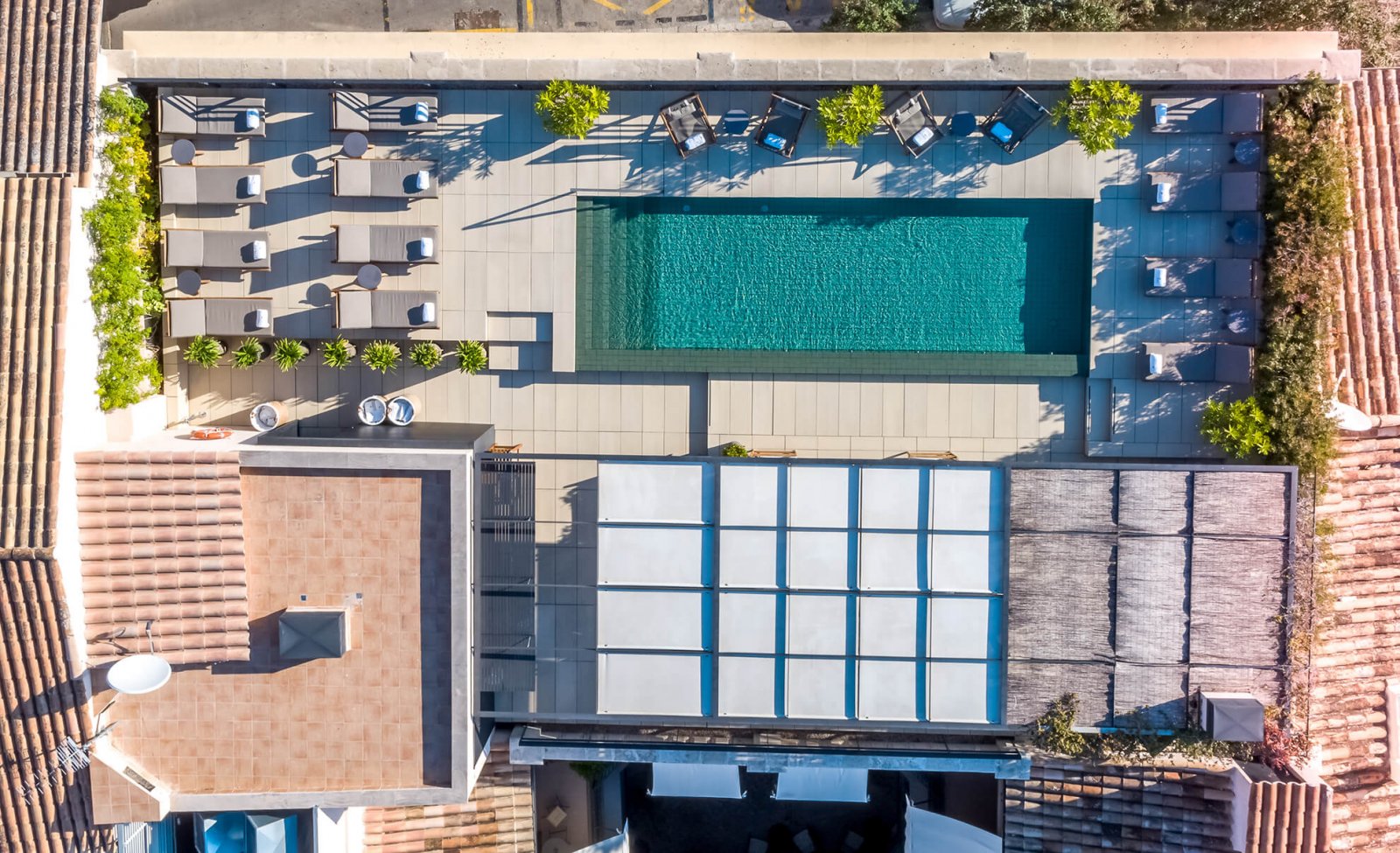 Overhead view of the upper terrace with rectangular pool and surrounded by an area for sunbathing, sitting, and a covered chillout area