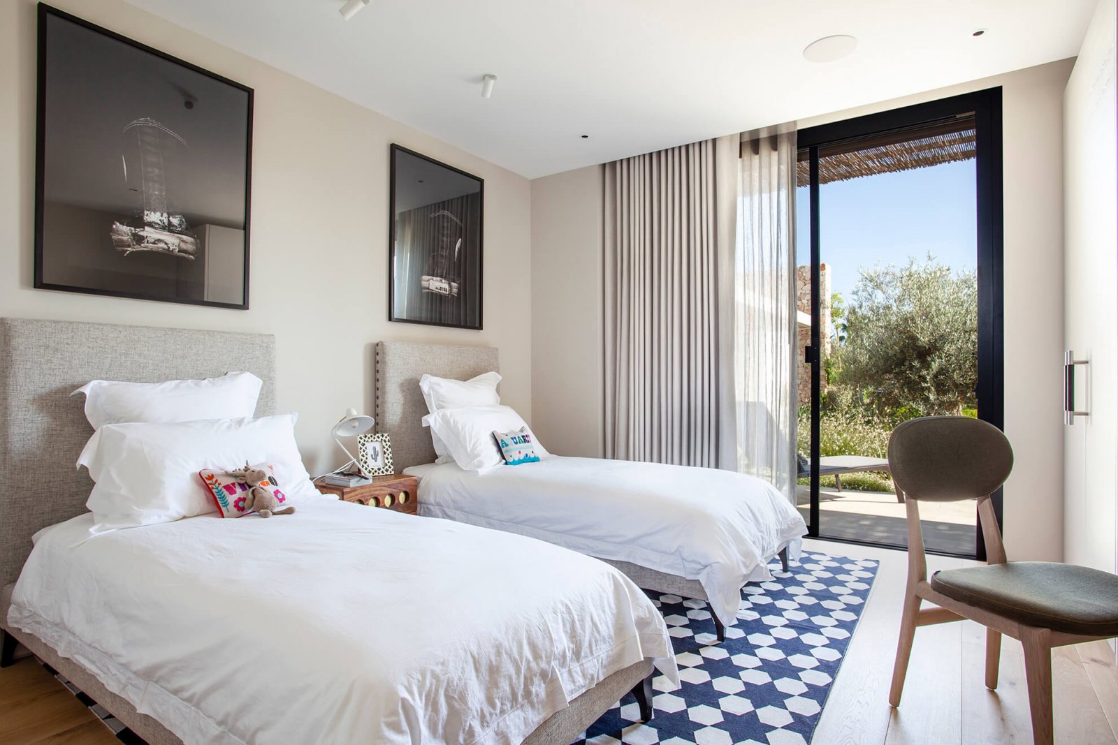 Detail view of a room, with two beds, built-in wardrobe and large glass doors to the garden of the Sol de Mallorca house