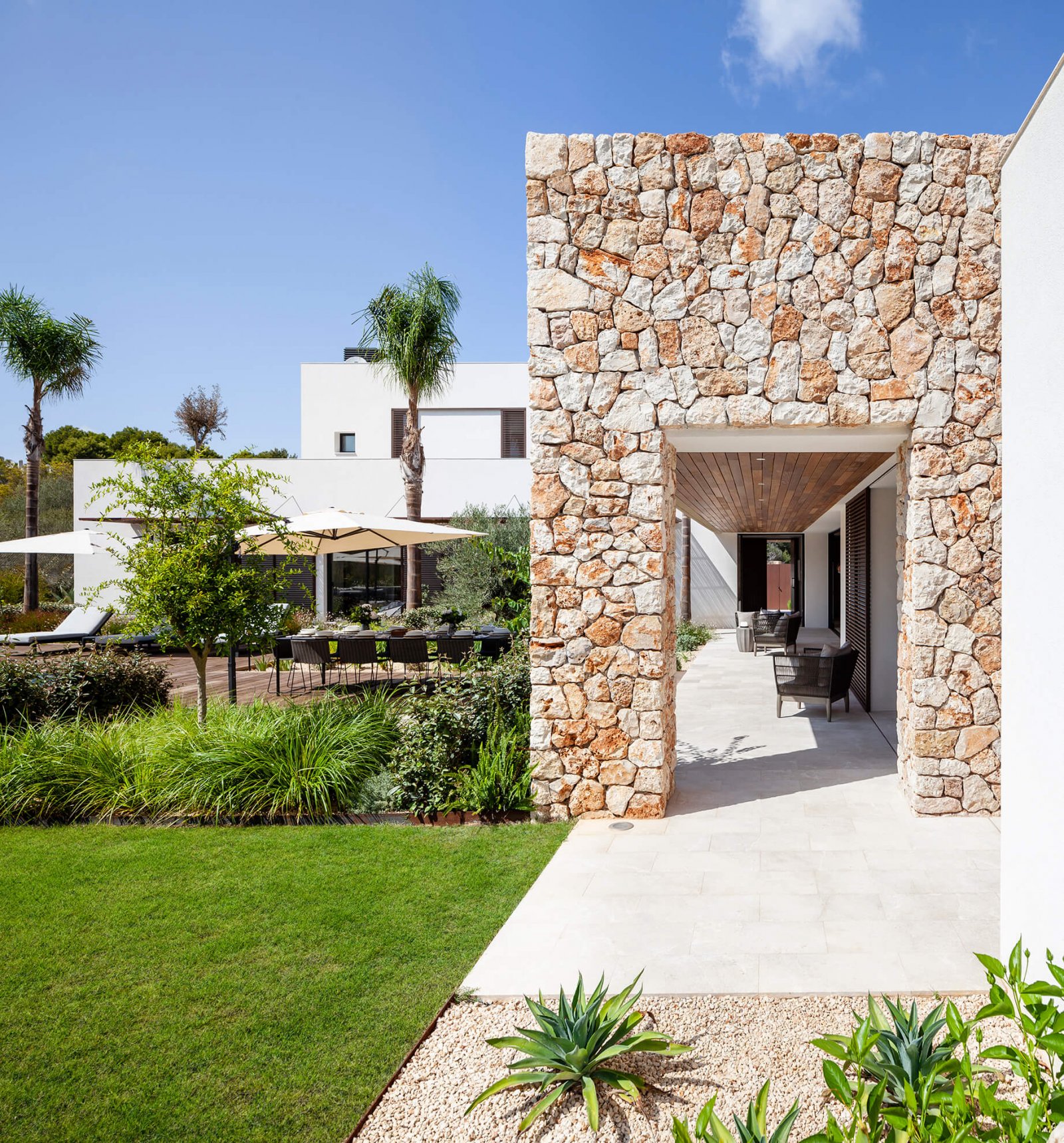 Another view of the garden, chill-out and stone facade of the Sol de Mallorca house