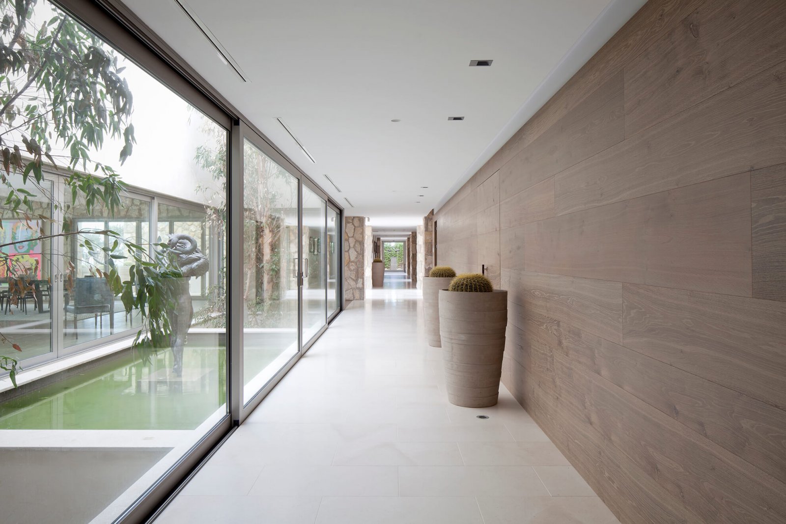 Detail view of one of the corridors of casa london, with sliding glass doors leading to an interior patio