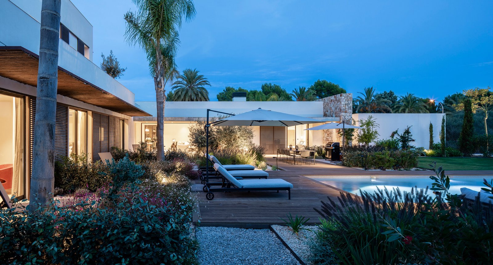 Side view of the garden with chill-out area and pool at night of the Sol de Mallorca house